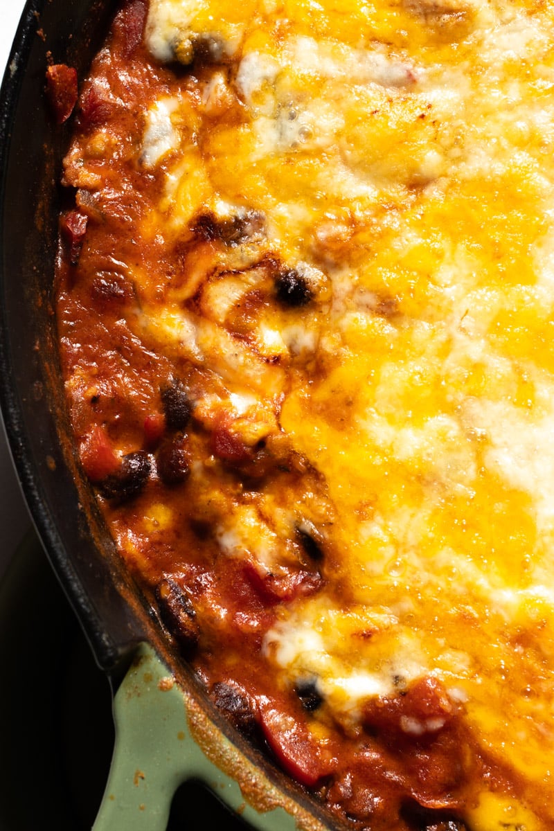 the lower left side of a pan full of cheesy chipotle ground chicken.