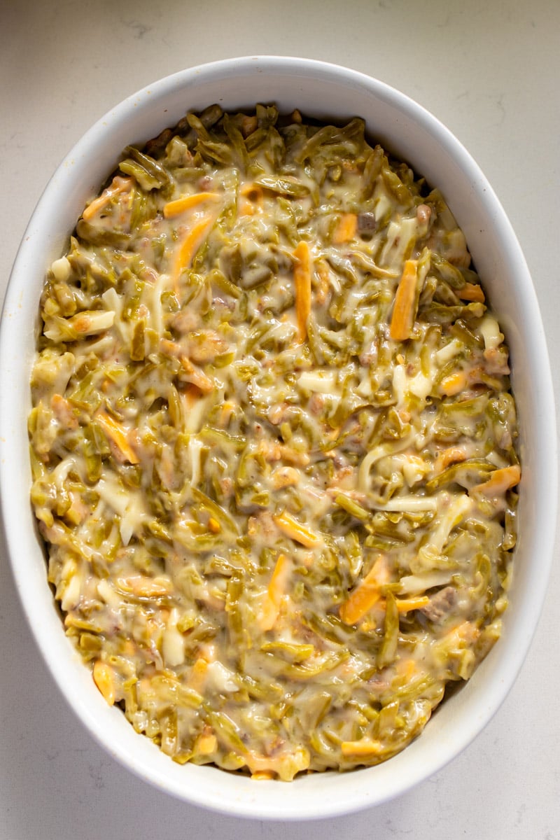 green bean casserole ingredients mixed together and set in a baking dish.