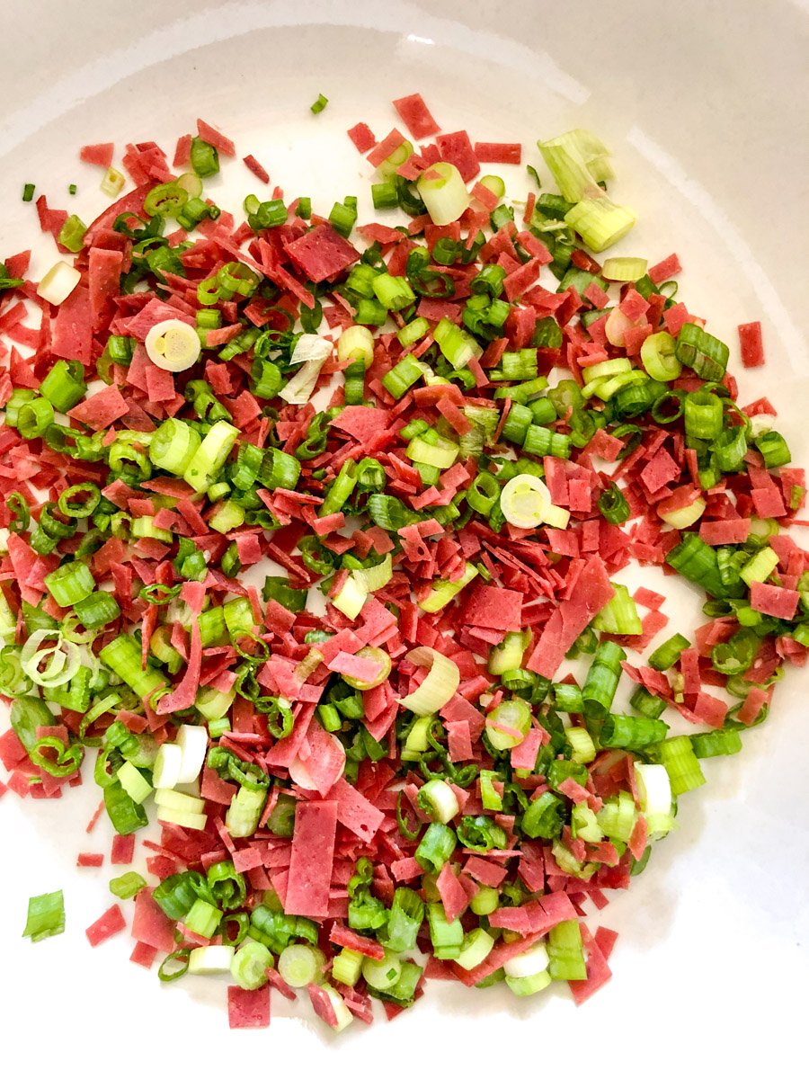 a bowl of chopped dried beef and green onion.