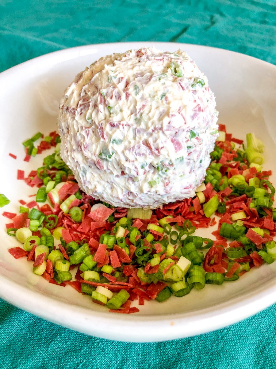 a shaped cream cheese and dried beef cheese ball in a white bowl. 