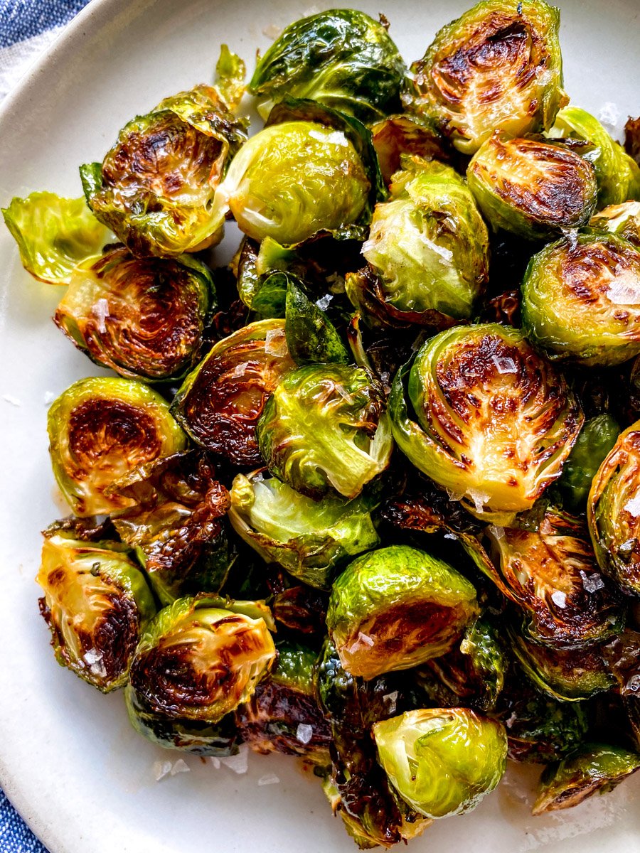 an up close view a plate of roasted brussels sprouts with a sriracha honey glaze.