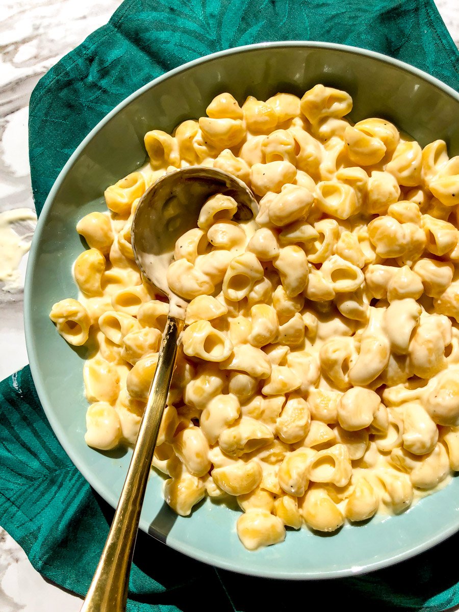 a big blue bowl filled with creamy white cheddar mac and cheese.