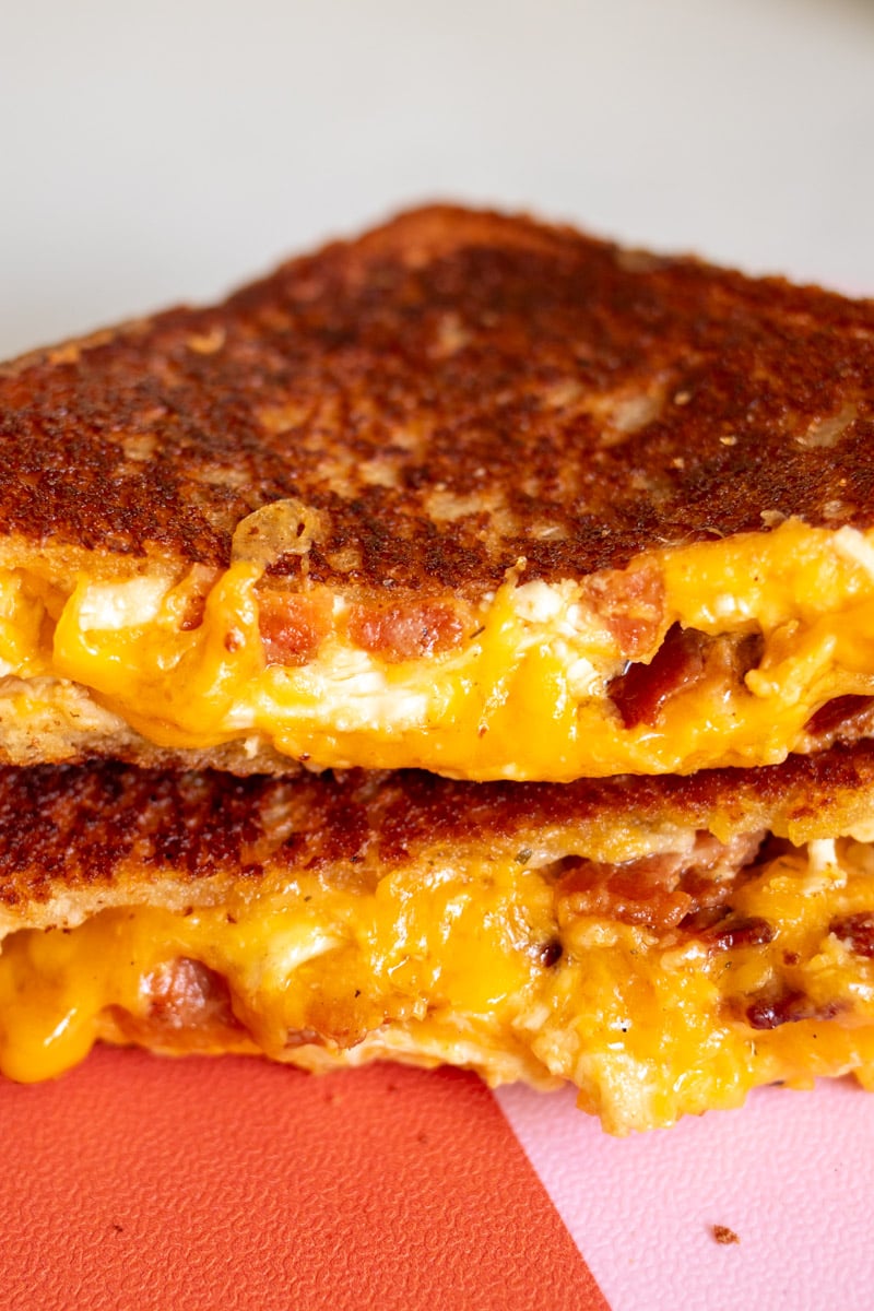 the gooey inside melting out of a chicken bacon ranch grilled cheese sandwich.