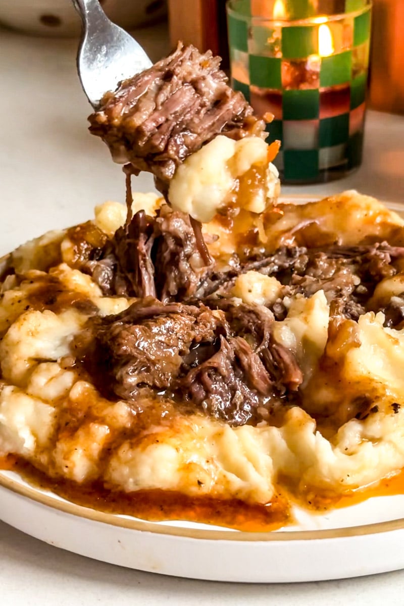 a fork scooping up a bite of braised beef chuck short ribs.