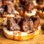 a garlic steak bite recipe on a slice of baguette with boursin cheese.