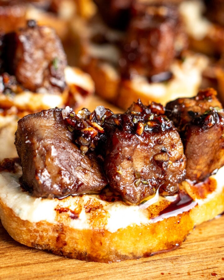 a garlic steak bite recipe on a slice of baguette with boursin cheese.