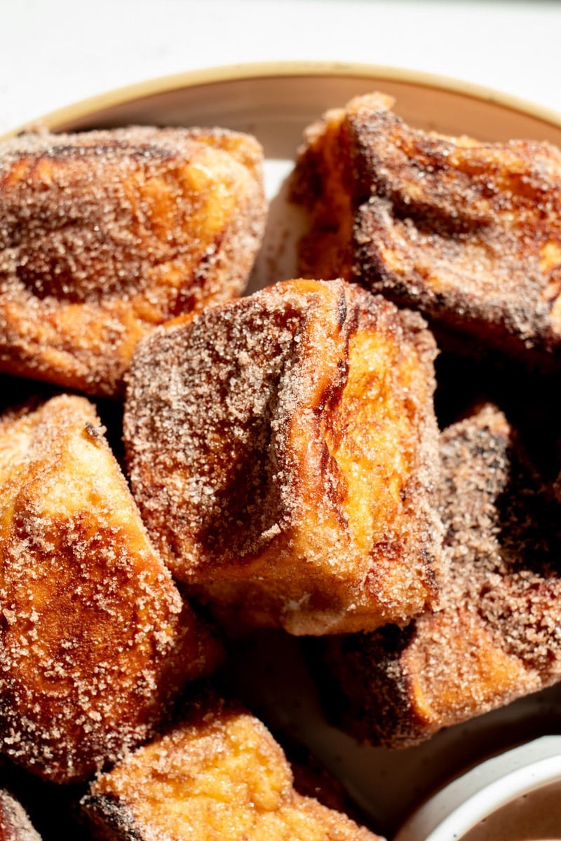 a plate full of hot cocoa dusted french toast bites.