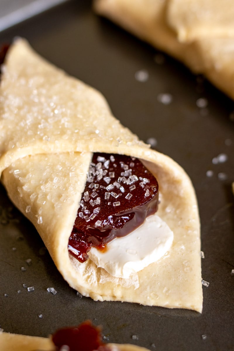 cuban pastries sprinkled with sparkling sugar on a baking sheet.