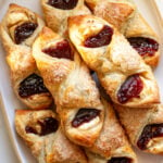 guava pastries with cream cheese stacked on top of each other on a white serving platter.