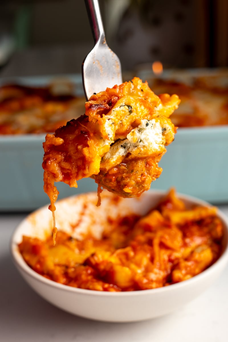 a fork holding a bite of lazy lasagna made from ravioli.