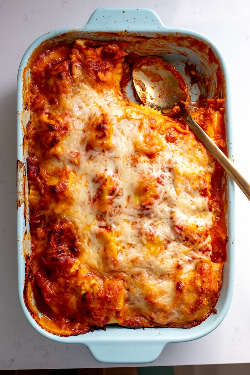 an overhead view of a blue baking dish filled with red and white lazy lasagna.