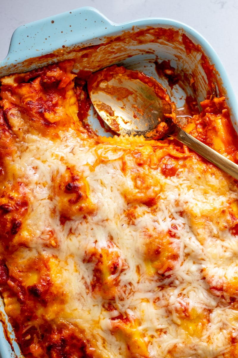 a baking dish full of lazy lasagna with a scoop missing and a golden spoon.