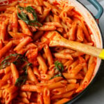 a pot of bright red pomodoro sauce with basil in it.