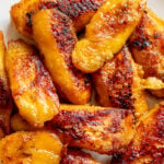 crispy and tender golden fried plantains on a white plate.