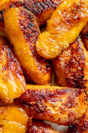 crispy and tender golden fried plantains on a white plate.