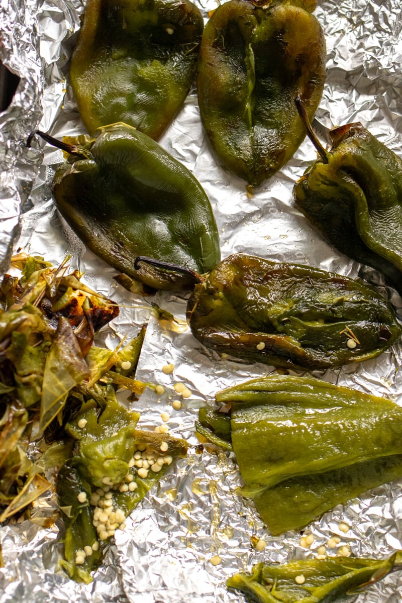 poblano peppers with their skins peeled off on a baking sheet.