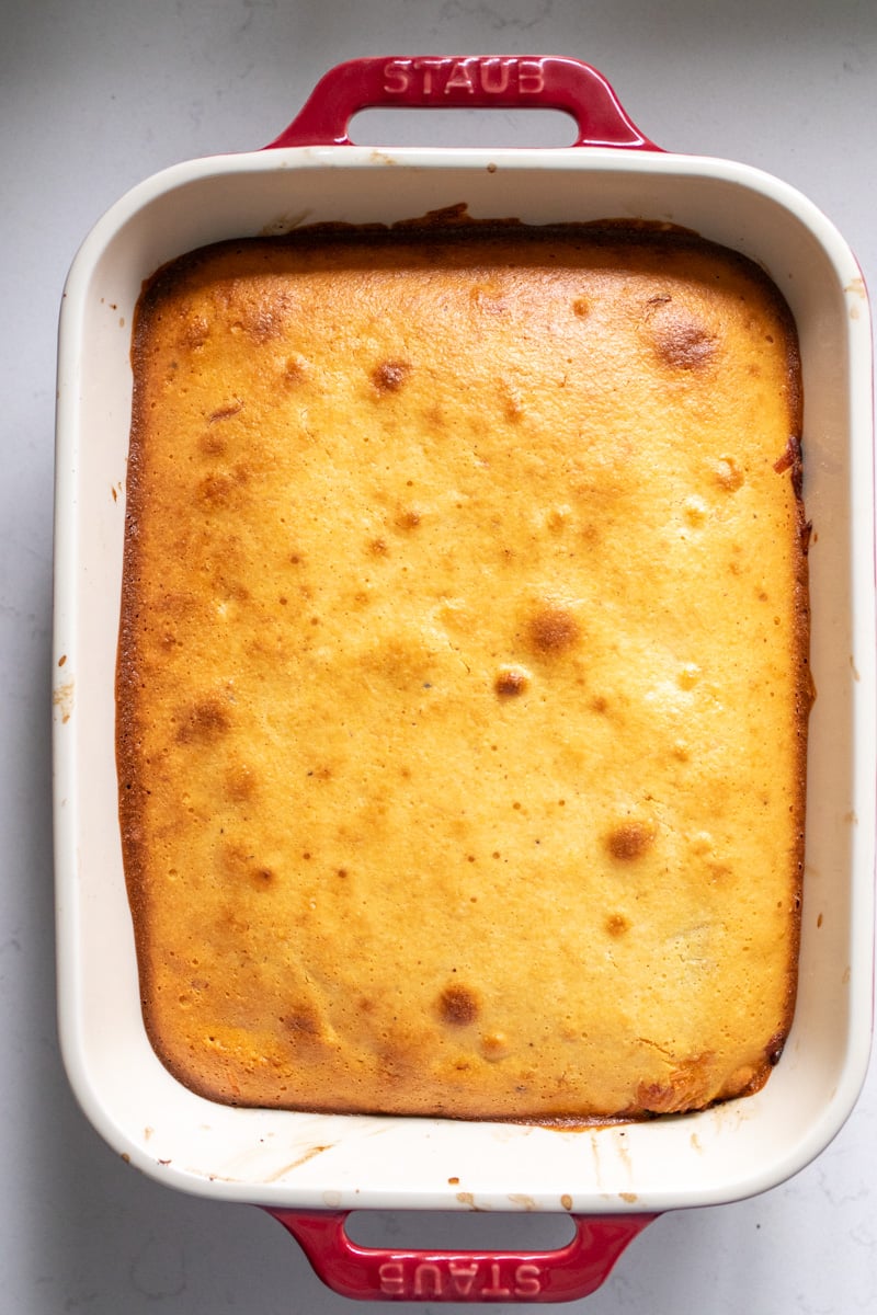 a freshly baked chile relleno casserole in a red staub baking dish.