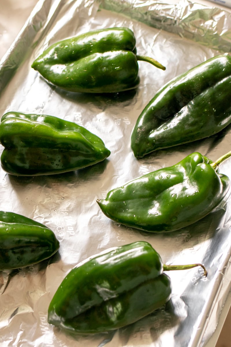 poblano chiles on a foil lined baking sheet.