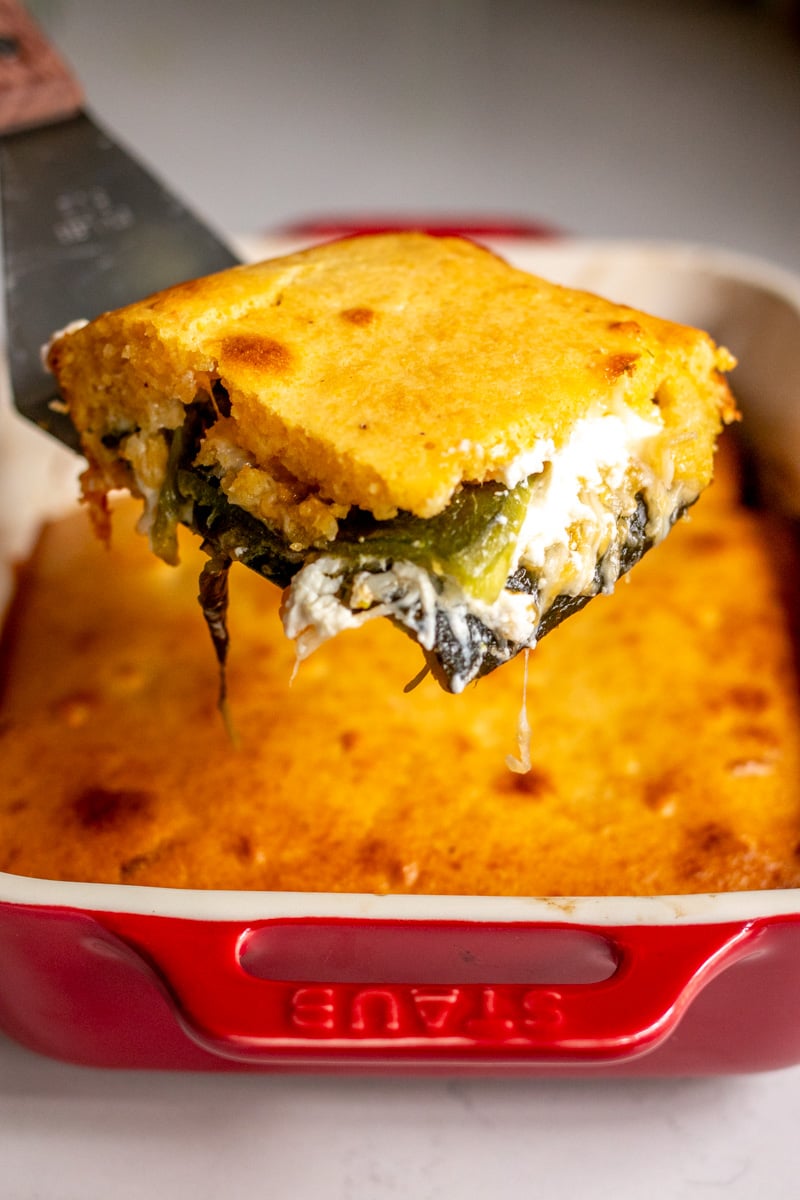 a scoop of chile relleno casserole being held up by a spatula.