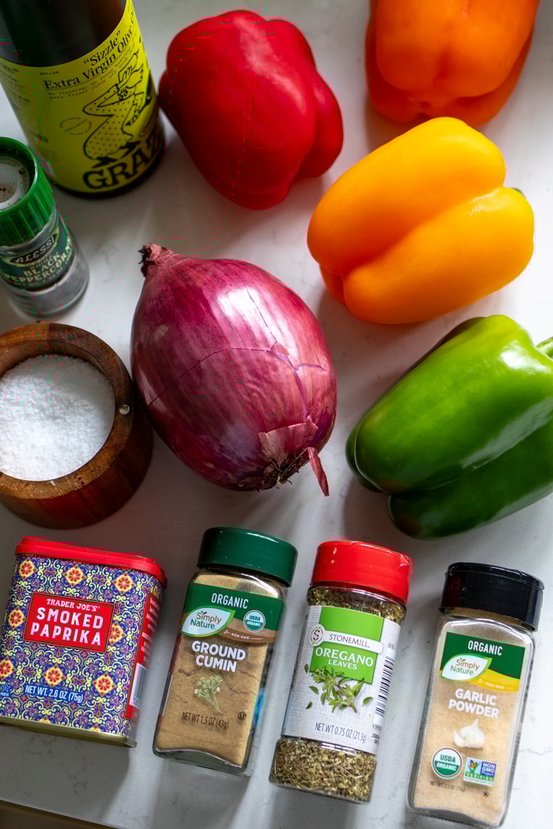 ingredients for fajita veggies laid out on a white countertop.