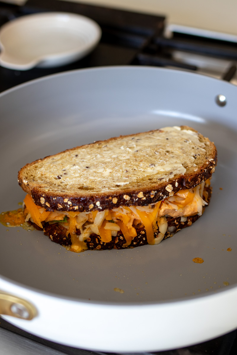 a buffalo chicken dip grilled cheese sandwich in a frying pan.