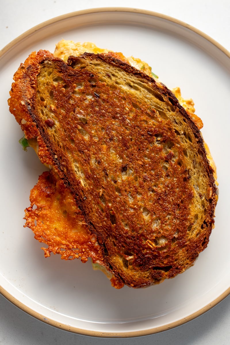 an overhead view of a whole buffalo chicken dip grilled cheese on a white plate. 