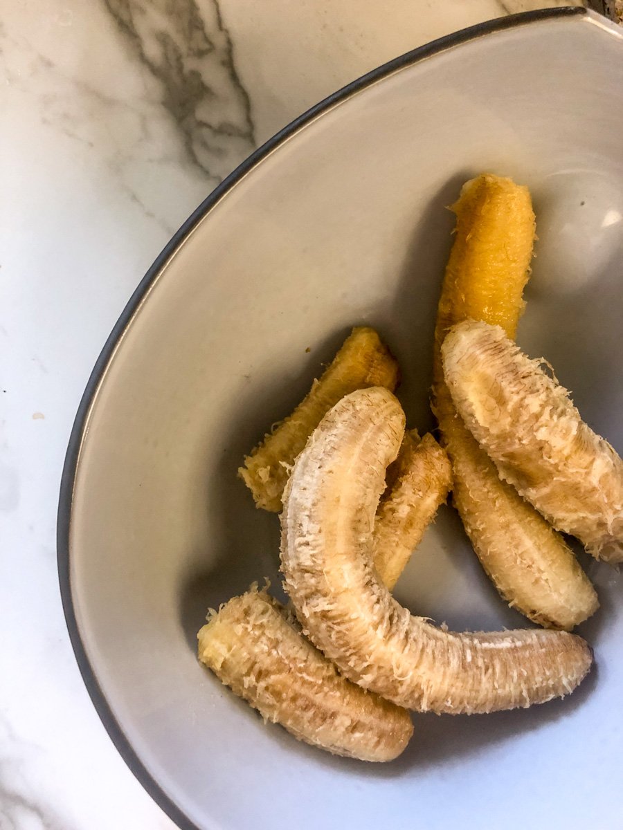 over ripe bananas in a ceramic bowl.