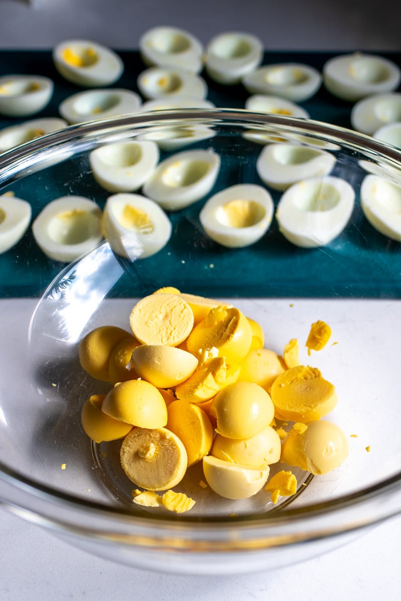 egg yolks in a bowl with the egg whites in the background.