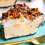 a slice of no bake peanut butter pie on a teal plate with a golden fork.