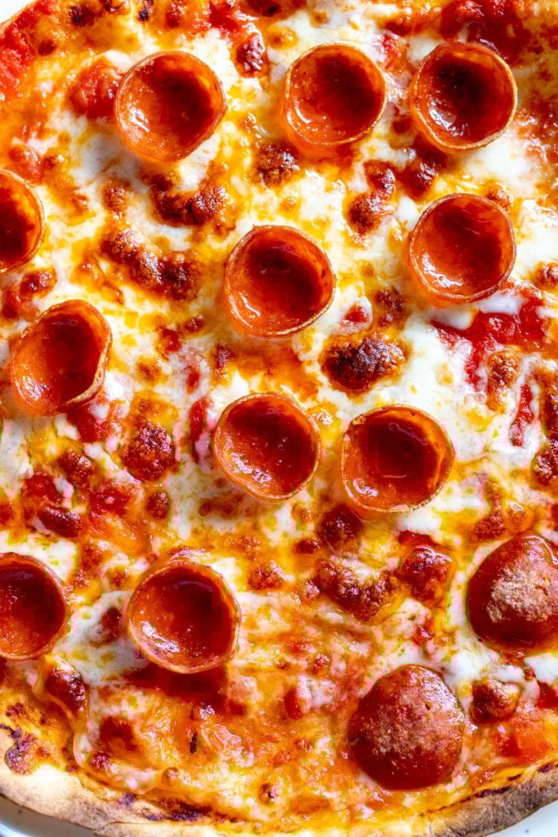 an up close view of the texture of the top of a tortilla pizza.