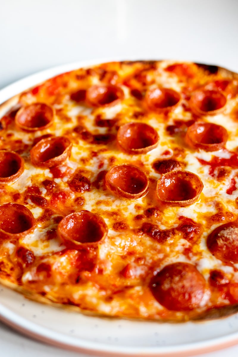 a side angled view of the crispy pepperoni cups on this tortilla pizza.
