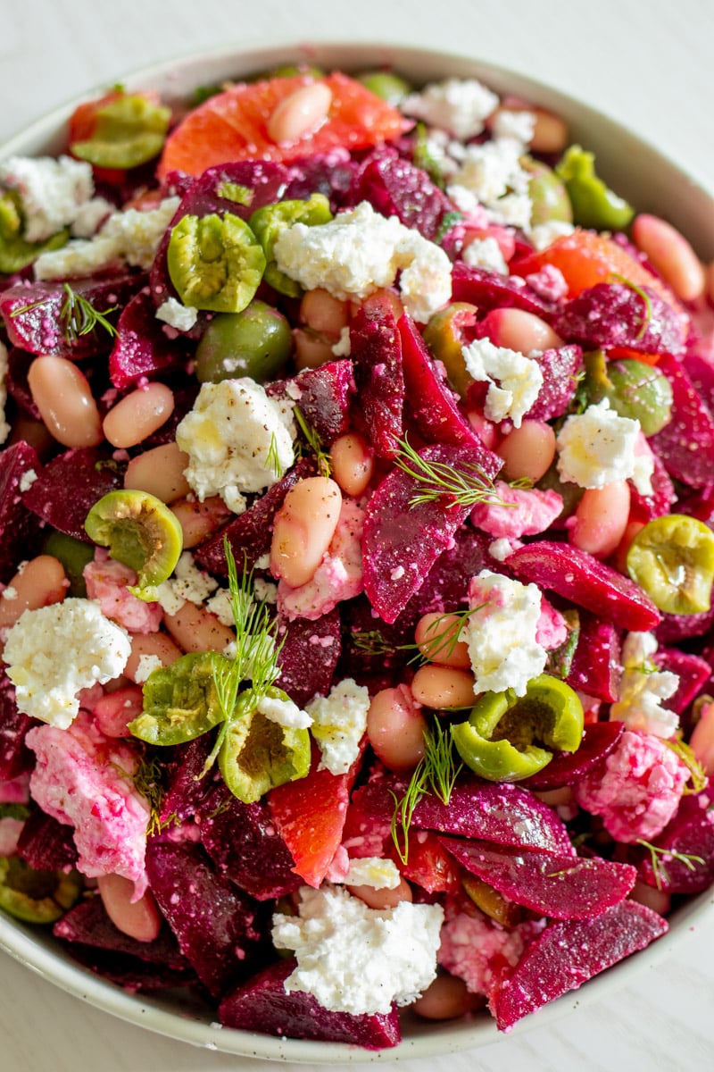 an overhead view of a white bowl full of a super colorful beet and feta salad.