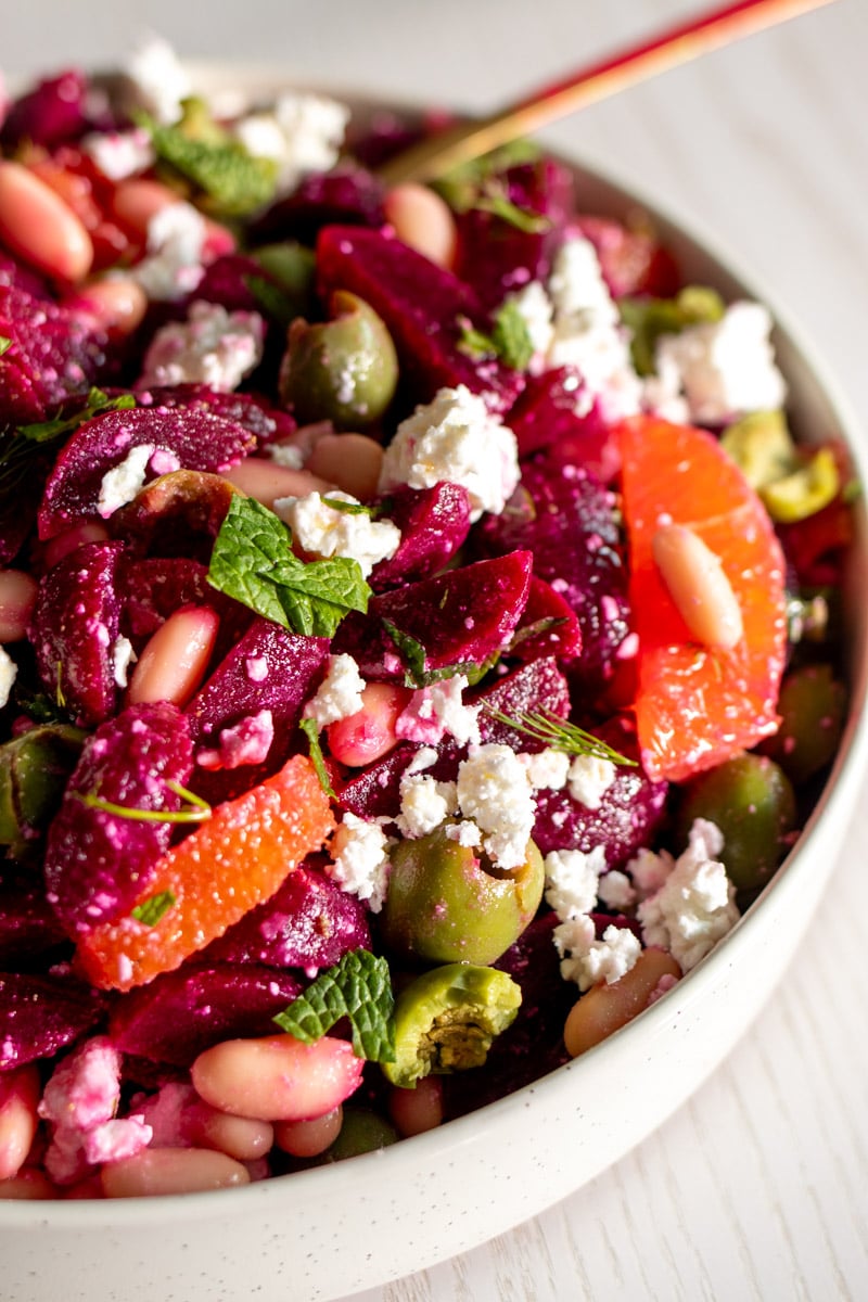 an overhead view of a pickled beet and feta salad with a golden spoon.