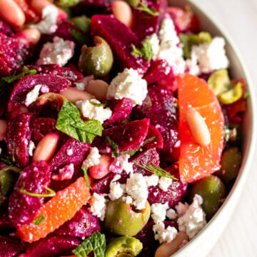 an overhead view of a colorful beet and feta salad in a white bowl.