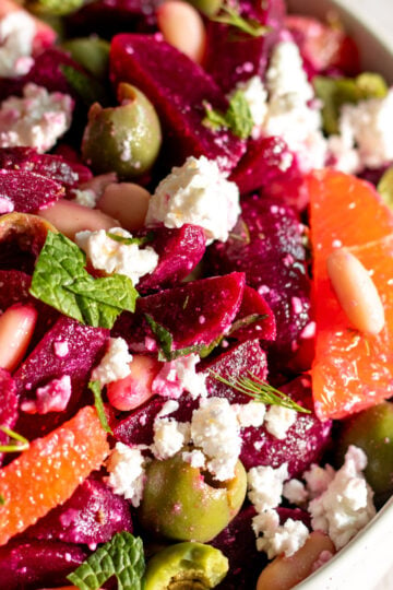 an overhead view of a colorful beet and feta salad in a white bowl.