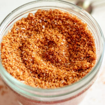 a small glass jar full of dry rub for ribs.