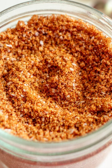 a small glass jar full of dry rub for ribs.