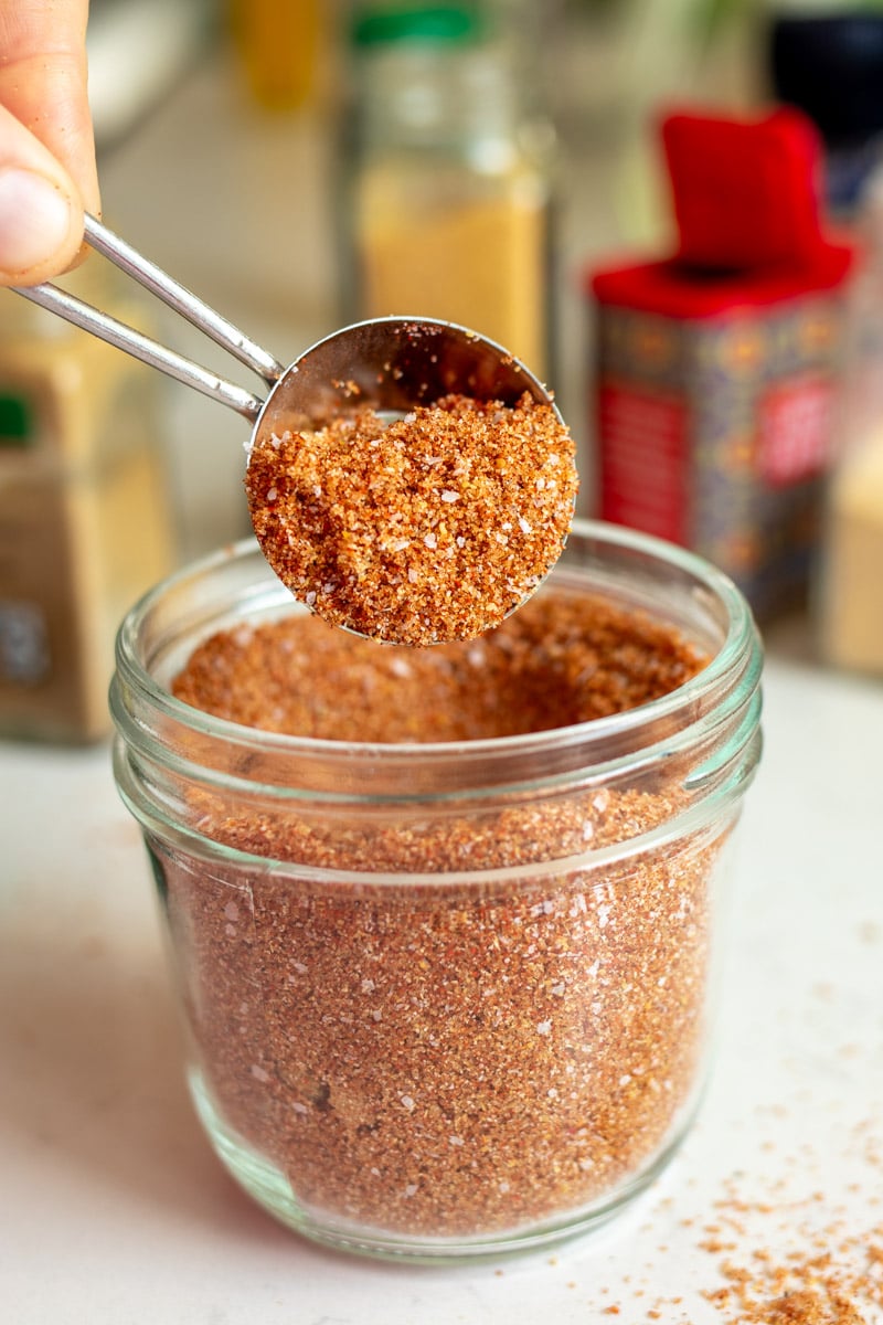 a small silver tablespoon scooping out a portion of this dry rub for ribs spice blend.