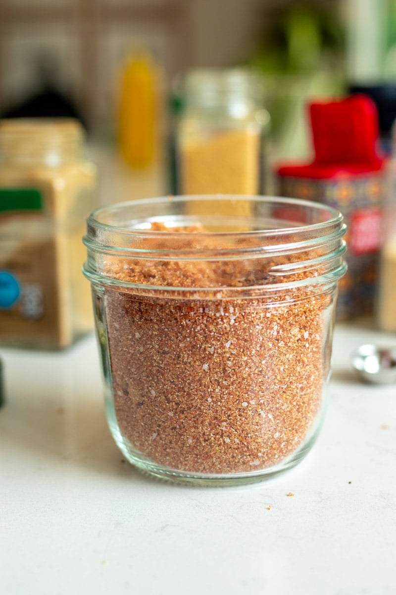 a jar of rib rub in front of a bunch of different spice jars. 