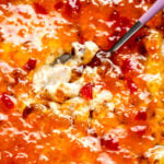 a close up view of a scoop of pepper jelly cheese dip.
