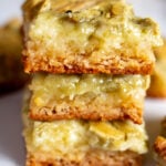 pistachio cream gooey butter cake pieces stacked on top of each other.