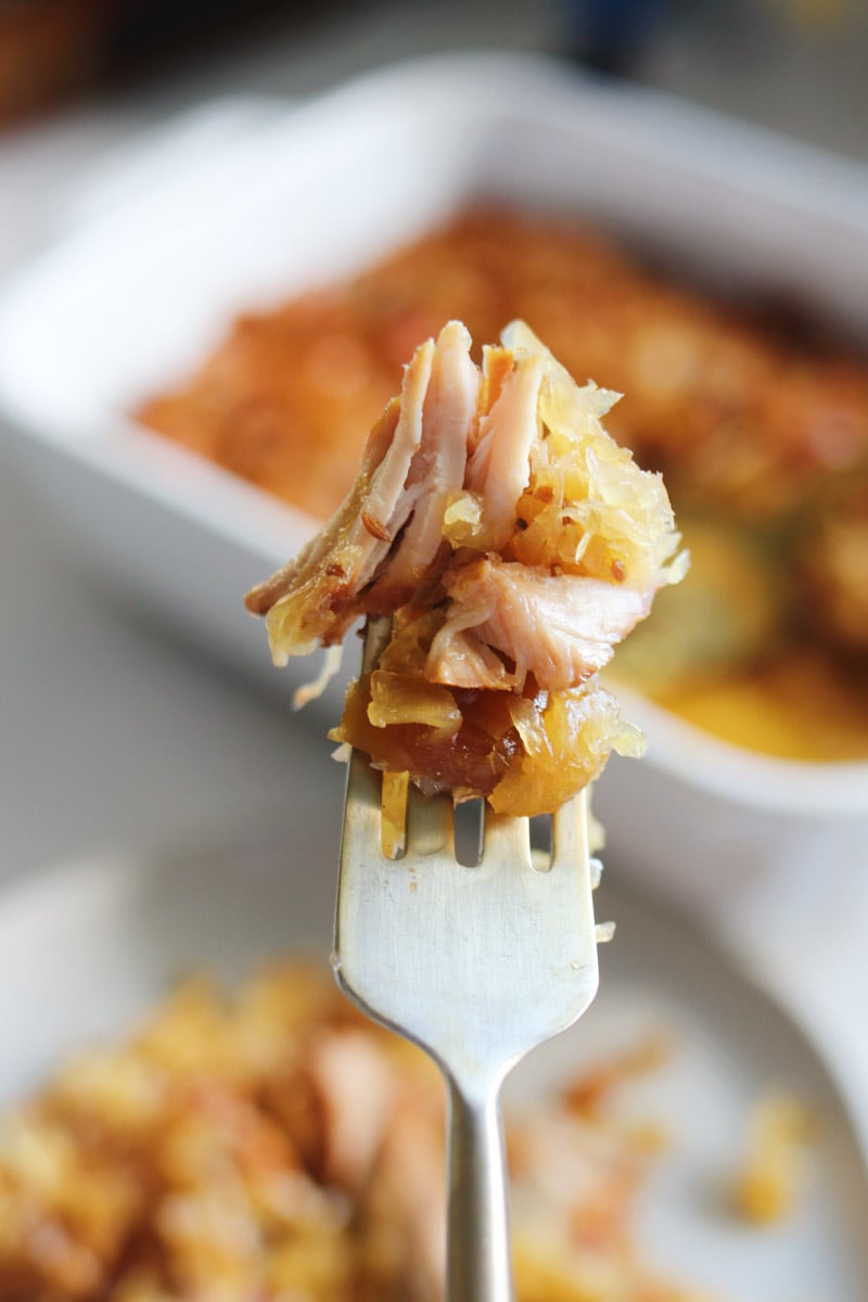 a fork holding a bite of tender sweet and savory pork. 