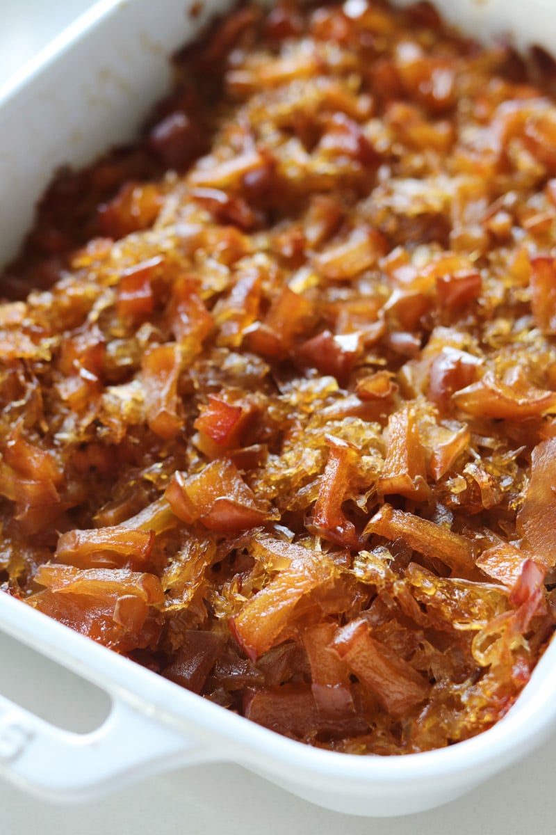 a baking dish with sauerkraut, pork, and apples.