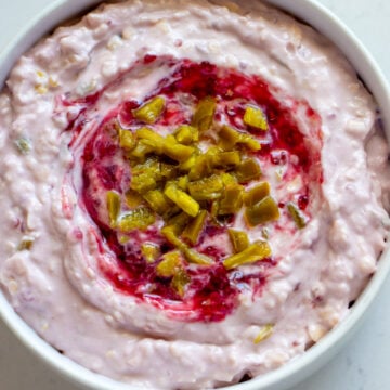 a white bowl filled with creamy raspberry jalapeno cheese dip.