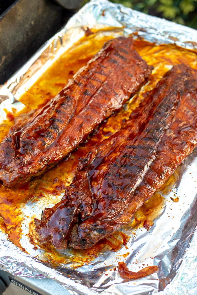 two racks of ribs with caramelized bbq sauce on them. 
