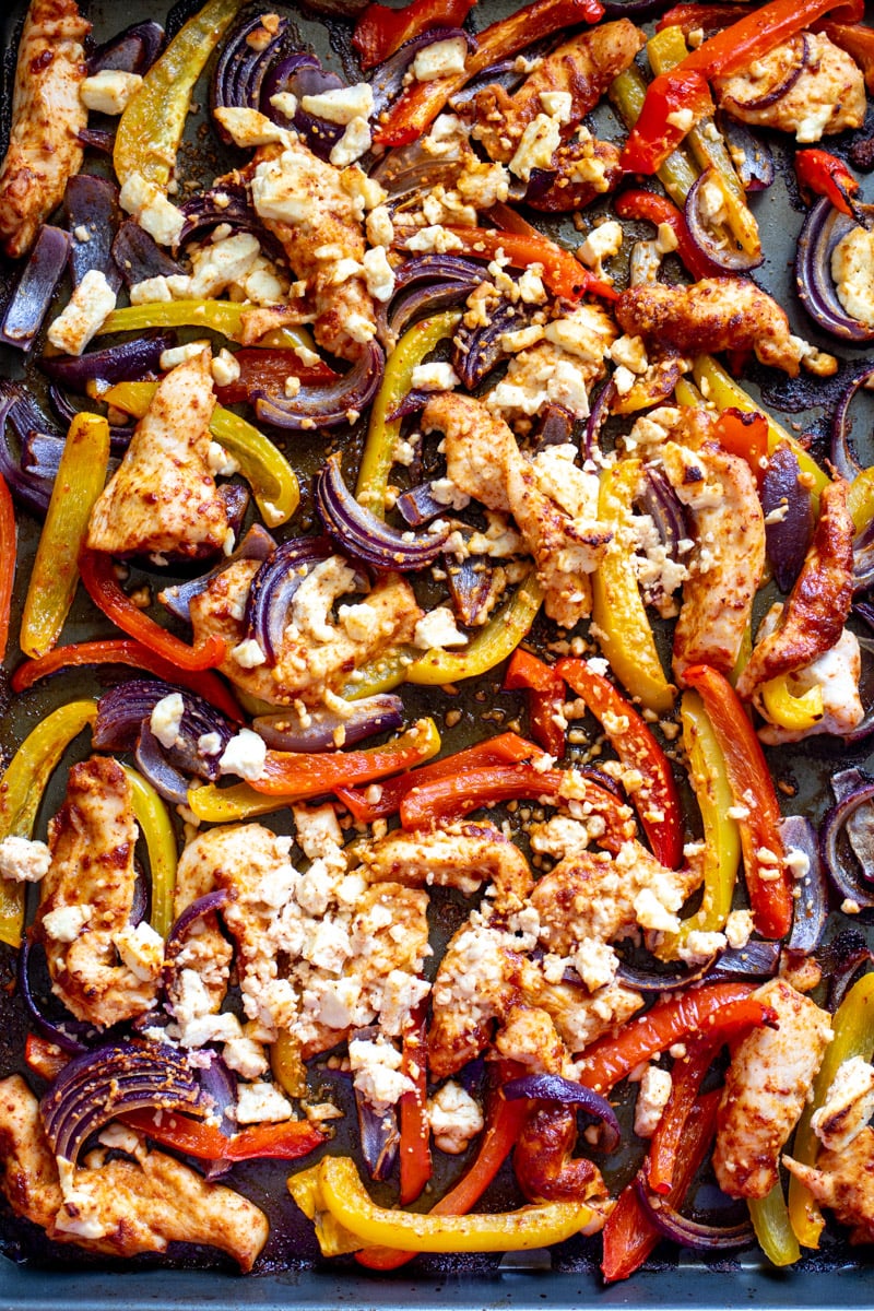 tajin feta, chicken, peppers and onions on a sheet pan.