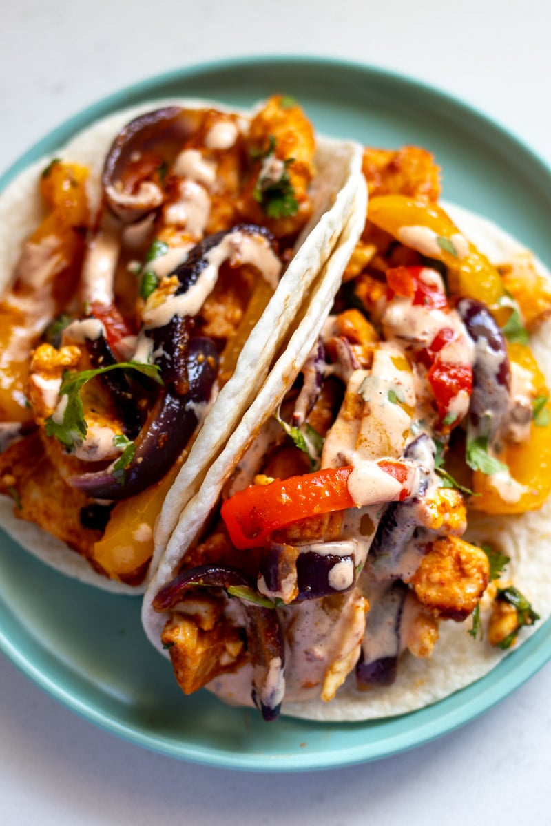 an up close view of the sheet pan fajitas on a blue plate.