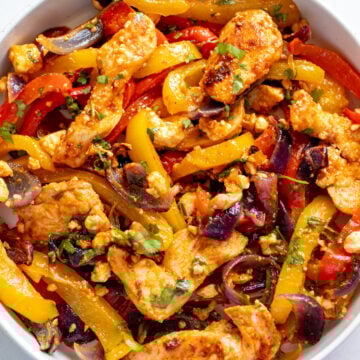 tajin feta sheetpan fajitas on a white bowl.