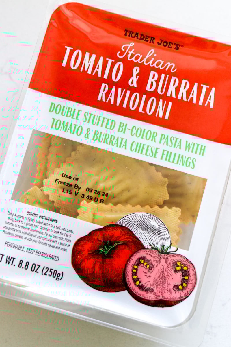 a box of trader joe's tomato burrata ravioloni sitting on a white table. 