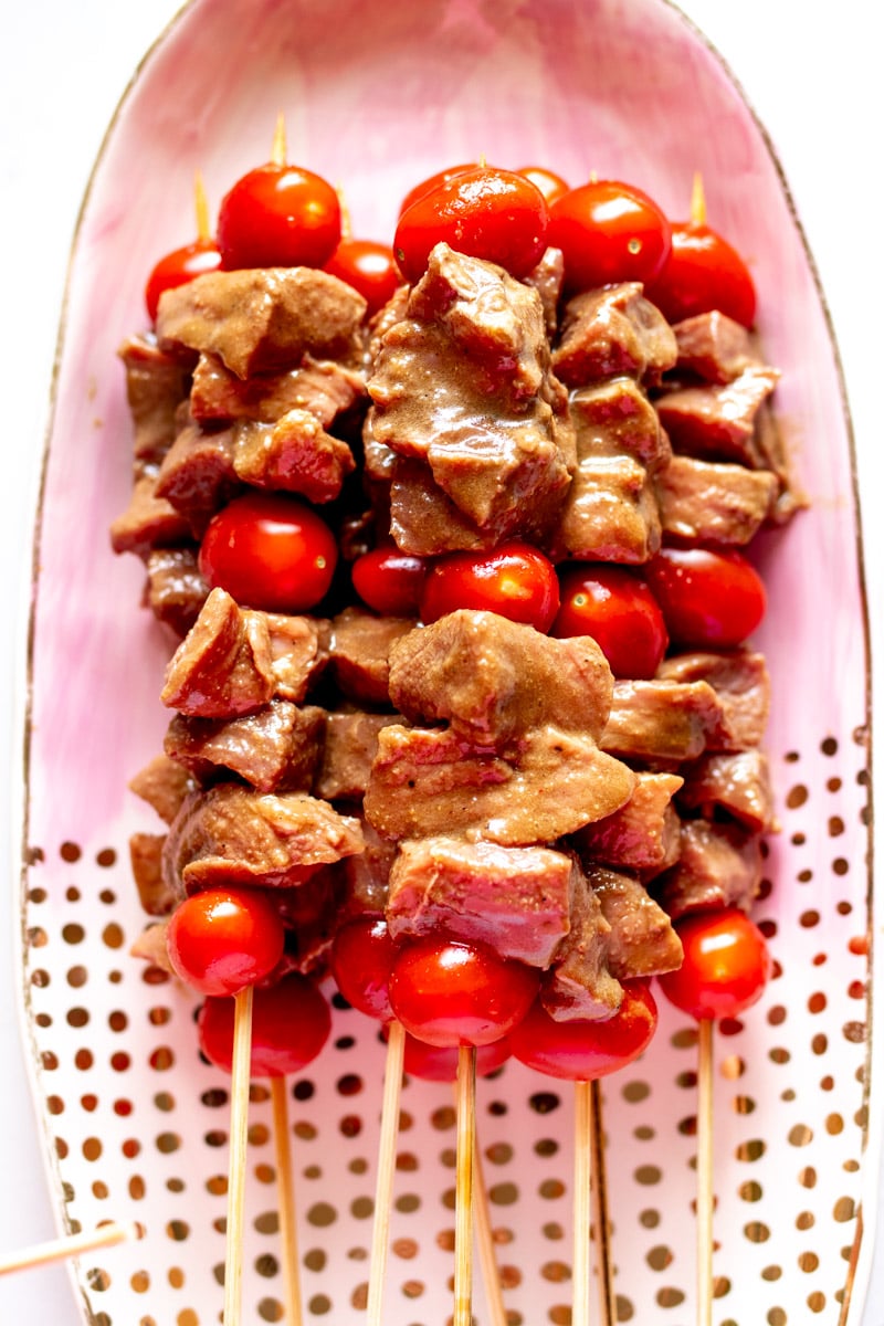 built steak skewers on a pink and gold polka plate. 